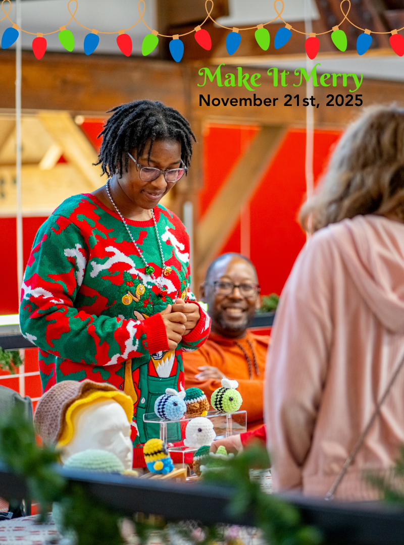 Person wearing a festive sweater with Christmas decorations, surrounded by people and holiday-themed knit items.