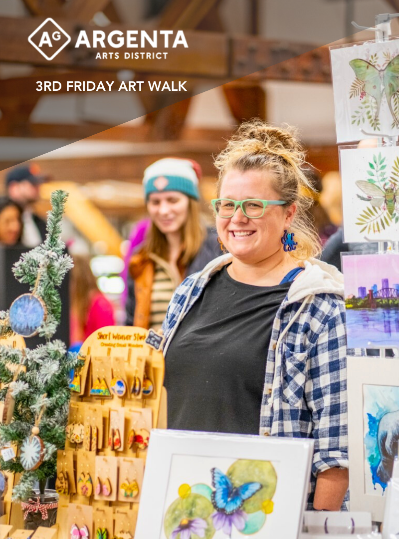 Ally displays hand made pieces in her Short Weaver Studio booth at an art walk event with artwork and a display tree in the background