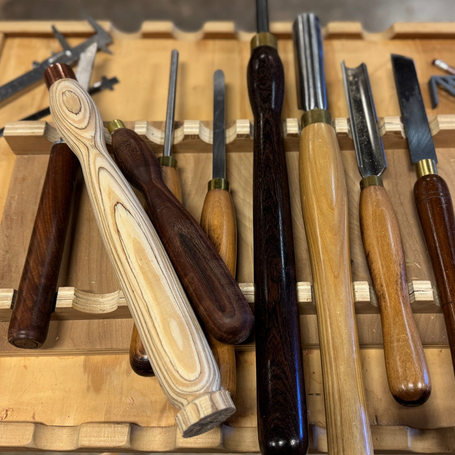 Set of wooden-handled tools on a wooden tray during woodturning class