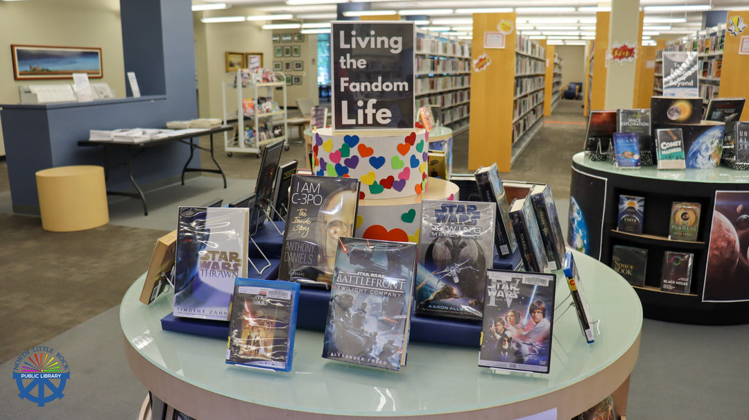 Display of books and items related to 'Star Wars' in a library setting with a sign that reads Living the Fandom Life
