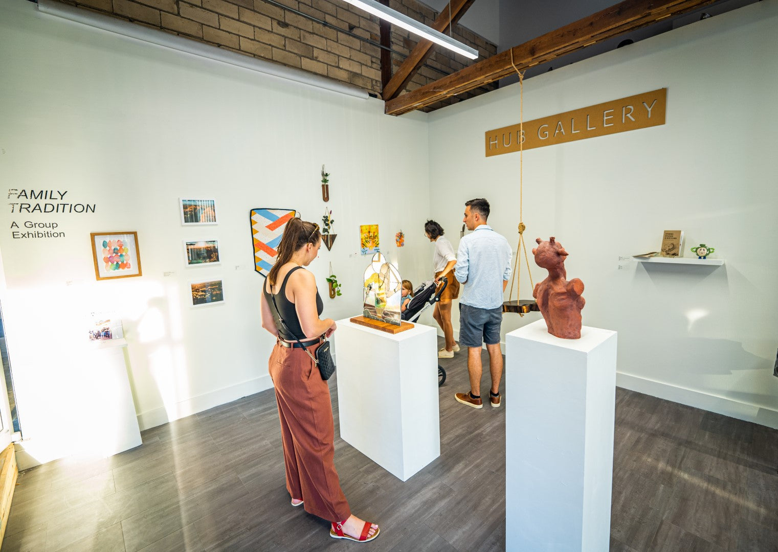 The Innovation Hub Art gallery with visitors examining artworks on white pedestals and unique pieces of art on the walls.